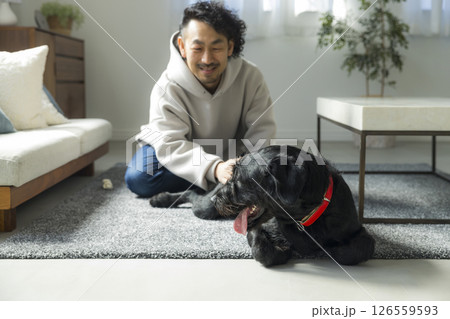 愛犬とリビングでくつろぐ男性 愛犬とリビングでくつろぐ男性 126559593