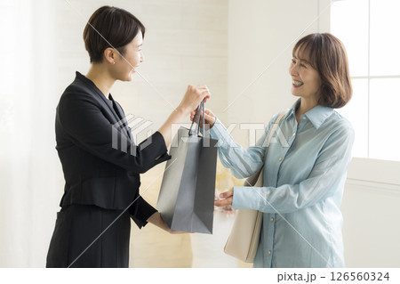 ショピングバッグを渡す女性 126560324