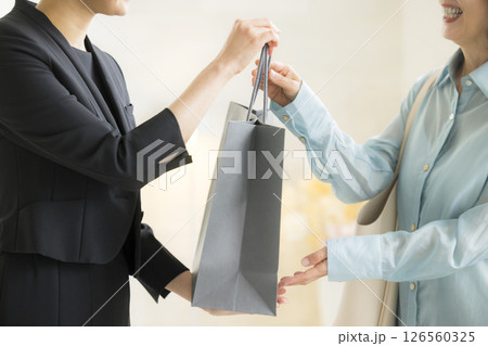 ショピングバッグを渡す女性 126560325