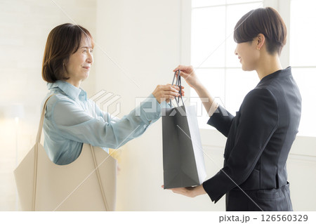 ショピングバッグを渡す女性 126560329