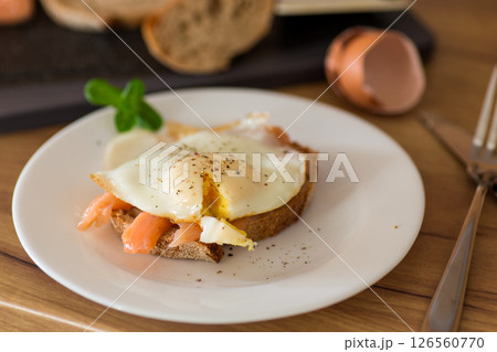 A slice of bread with lightly salted red fish and a cooked egg for breakfast 126560770