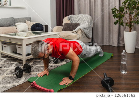 Man doing push-ups at home gym during workout session 126561562