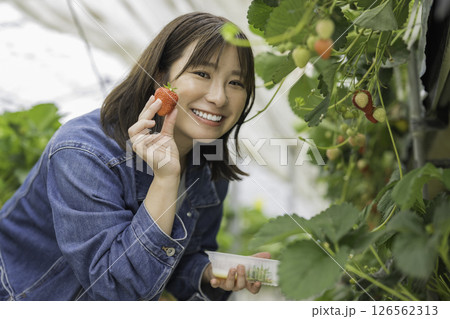 笑顔でいちごを持つ女性 126562313