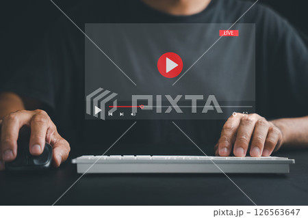Experience the convenience of online connectivity as a man uses a computer for video streaming, attending live events, and engaging with educational tutorials. Experience the convenience of online connectivity as a man uses a computer for video streaming, attending live events, and engaging with educational tutorials. 126563647
