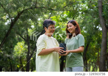 Old Asian Women and daughter join as volunteers for reforestation, earth conservation activities for reduce global warming growth feature and take care nature earth. Environment Concept 126563736