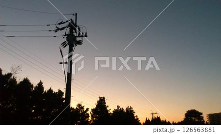 夕暮れの空に浮かぶ電柱のシルエット 126563881