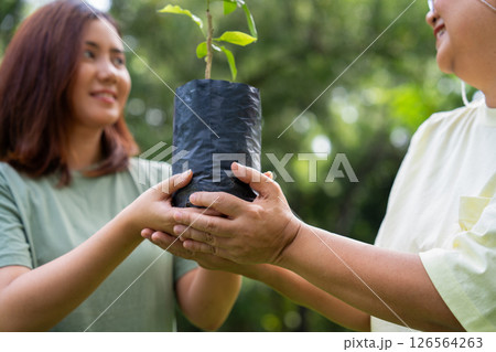 Old Asian Women and daughter join as volunteers for reforestation, earth conservation activities for reduce global warming growth feature and take care nature earth. Environment Concept Old Asian Women and daughter join as volunteers for reforestation, earth conservation activities for reduce global warming growth feature and take care nature earth. Environment Concept 126564263