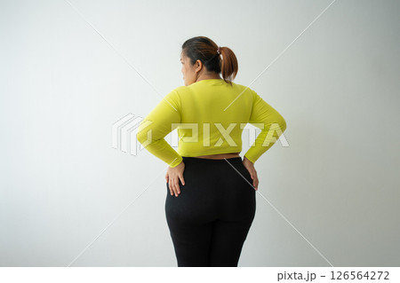 Overweight woman using a tape measure around waist and belly fat, Fat Asian woman workout at home. Concept of healthy, food for health and lifestyle, weight loss Overweight woman using a tape measure around waist and belly fat, Fat Asian woman workout at home. Concept of healthy, food for health and lifestyle, weight loss 126564272