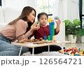 Cherry young mother plays colorful toy block with her Down syndrome daughter,  colorful wooden toys can increase skills and learning to increase the development, special education, Knowing slowly 126564721