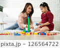 Cherry young mother plays colorful toy block with her Down syndrome daughter,  colorful wooden toys can increase skills and learning to increase the development, special education, Knowing slowly 126564722