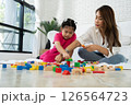 Cherry young mother plays colorful toy block with her Down syndrome daughter,  colorful wooden toys can increase skills and learning to increase the development, special education, Knowing slowly 126564723