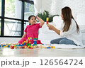 Cherry young mother plays colorful toy block with her Down syndrome daughter,  colorful wooden toys can increase skills and learning to increase the development, special education, Knowing slowly 126564724