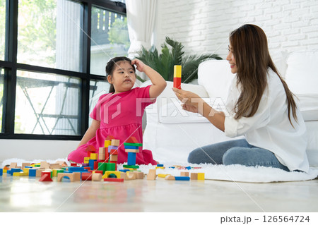 Cherry young mother plays colorful toy block with her Down syndrome daughter,  colorful wooden toys can increase skills and learning to increase the development, special education, Knowing slowly 126564724