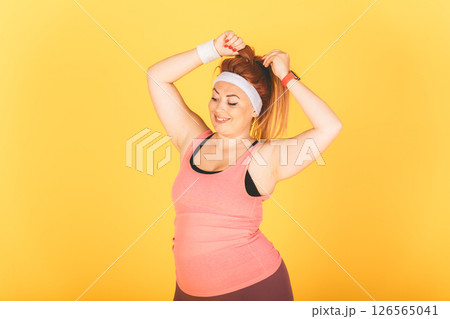A woman in a pink tank top is doing a workout A woman in a pink tank top is doing a workout 126565041