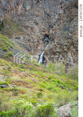 Mountain cliffs surrounding Chulyshman valley with visible waterfall Altai Russia Dramatic natural landscape with high rocks and falling water Mountain cliffs surrounding Chulyshman valley with visible waterfall Altai Russia Dramatic natural landscape with high rocks and falling water 126567256