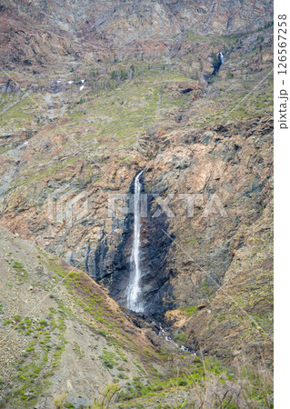 Mountain cliffs surrounding Chulyshman valley with visible waterfall Altai Russia Dramatic natural landscape with high rocks and falling water 126567258