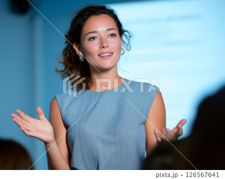 Confident young woman delivering a professional presentation during a meeting or conference session indoors 126567641