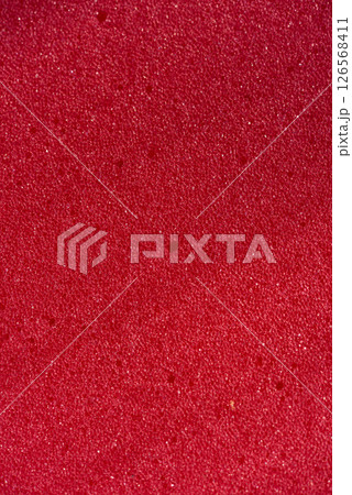 Background of porous foam rubber. Red foam rubber. Packaging material. 126568411