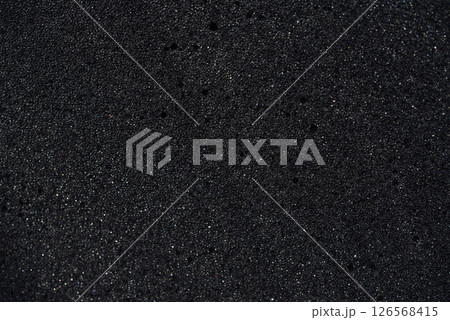 Background of porous foam rubber. Black foam rubber. Packaging material. 126568415
