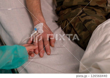 Holding hands in a hospital symbolizes affection, comfort, and support during recovery 126568440