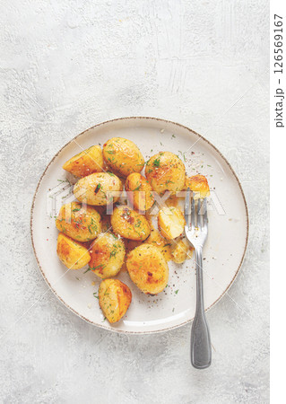 half-eaten fried new potatoes, with butter and dill, on a white plate, with a fork, at home, no people, half-eaten fried new potatoes, with butter and dill, on a white plate, with a fork, at home, no people, 126569167