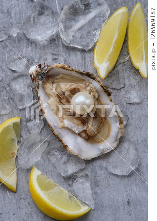 Oyster with pearl and lemons on a gray background 126569187