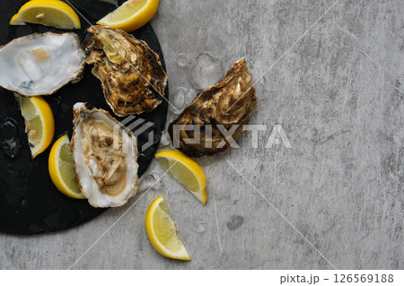 open oysters and lemons on the table 126569188