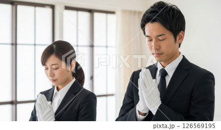 白手袋で合掌する男女の葬儀スタッフ（AI生成画像） 126569195