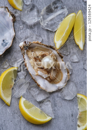 Oyster with pearl and lemons on a gray background 126569424