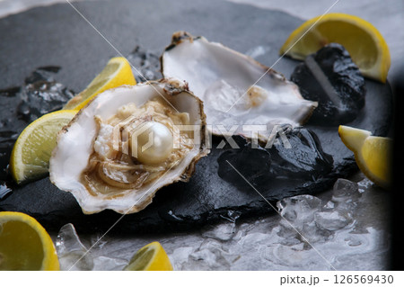Oyster with pearl and lemons on a gray background 126569430