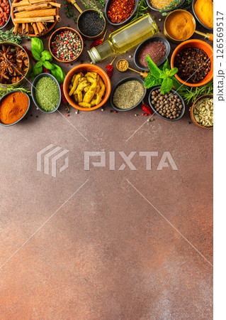 A colorful assortment of fragrant herbs and spices on a warm brown background, showcasing their visual variety and aromatic appeal 126569517