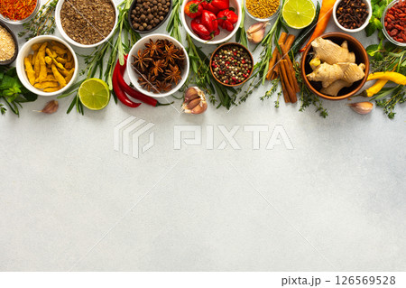 A vibrant assortment of spices and herbs on a gray background, offering a flavorful addition to any recipe, top view and copy space 126569528