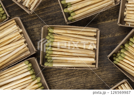 wooden matches with green grey poured into cardboard boxes , the green head of a wooden match laid out in cardboard boxes 126569987