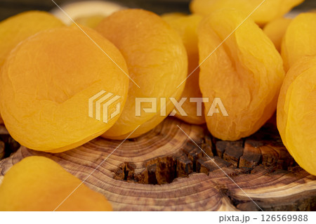 yellow dried apricots , a lot of dried dried apricots are dehydrated after removing the seeds, apricots on a wooden board 126569988