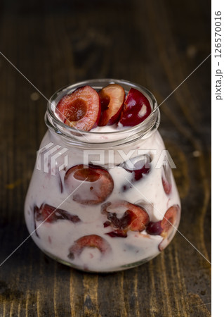 yogurt with cherry flavor , jar with cherry yogurt with fresh red cherries yogurt with cherry flavor , jar with cherry yogurt with fresh red cherries 126570016