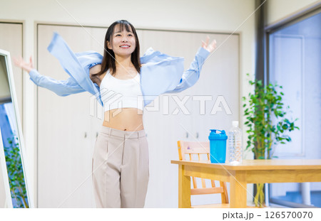 服を脱ぎ捨て、着替えてジムに向かう私服の若い女性　ヨガ　ストレッチ　ダイエット　健康 126570070