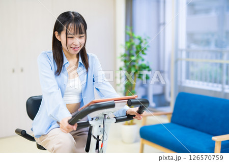 自宅の部屋でフィットネスバイクで運動する女性 家 エアロバイク 運動 自宅の部屋でフィットネスバイクで運動する女性 家 エアロバイク 運動 126570759