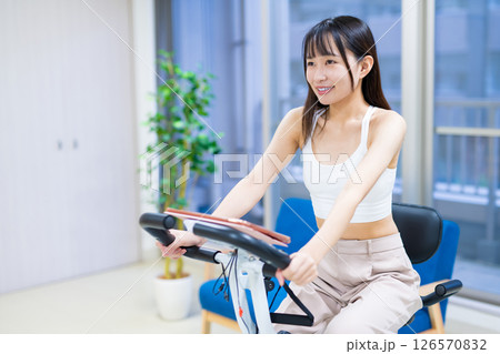 自宅の部屋でフィットネスバイクで運動する女性 家 エアロバイク 運動 自宅の部屋でフィットネスバイクで運動する女性 家 エアロバイク 運動 126570832