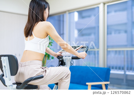 自宅の部屋でフィットネスバイクで運動する女性 家 エアロバイク 運動 自宅の部屋でフィットネスバイクで運動する女性 家 エアロバイク 運動 126570862