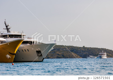 Line of many luxury smal cruise yacht boat ship docked Croatian bay harbor shore blue  clear water bright summer sunny sunset sunrise morning. Rich quality lifestyle. Boat vessel charter service 126571501