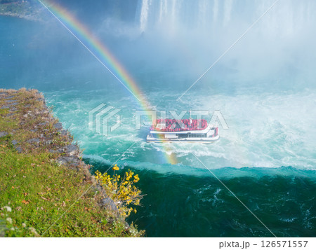 Niagara Falls. A pleasure boat with people near the huge famous waterfall. 126571557