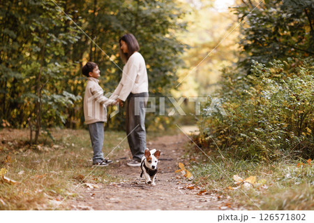Mother and Son Holding Hands with Dog in Autumn Forest Mother and Son Holding Hands with Dog in Autumn Forest 126571802