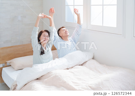起床して伸びをするシニア夫婦 126572344