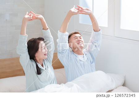 起床して伸びをするシニア夫婦 起床して伸びをするシニア夫婦 126572345