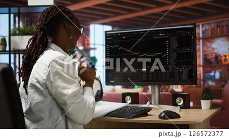 Smiling investor having success with cryptocurrency investment after buying low and selling high, making money. Joyous person celebrating financial gain after investing during bear market, camera A 126572377