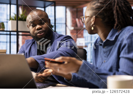 African american girl confronting her boyfriend about spending too much money, checking the balance on their joint savings account. Couple having some financial problems, banking debt. 126572428
