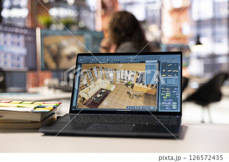 Freelancer designer decorates an apartment floor plan on a computer, using architectural software to configure elements. Woman uses interface to enable rendering and 3D modeling. 126572435