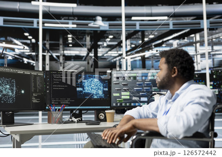 Engineer with paraplegia in inclusive data center using artificial intelligence visualization tools to identify bugs. Server hub worker with disability in wheelchair using AI insights to detect errors Engineer with paraplegia in inclusive data center using artificial intelligence visualization tools to identify bugs. Server hub worker with disability in wheelchair using AI insights to detect errors 126572442