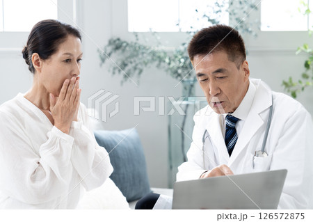 男性医師から説明を受ける女性 126572875