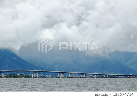 新緑の山を覆う雲と湖に架かる橋 新緑の山を覆う雲と湖に架かる橋 126574714